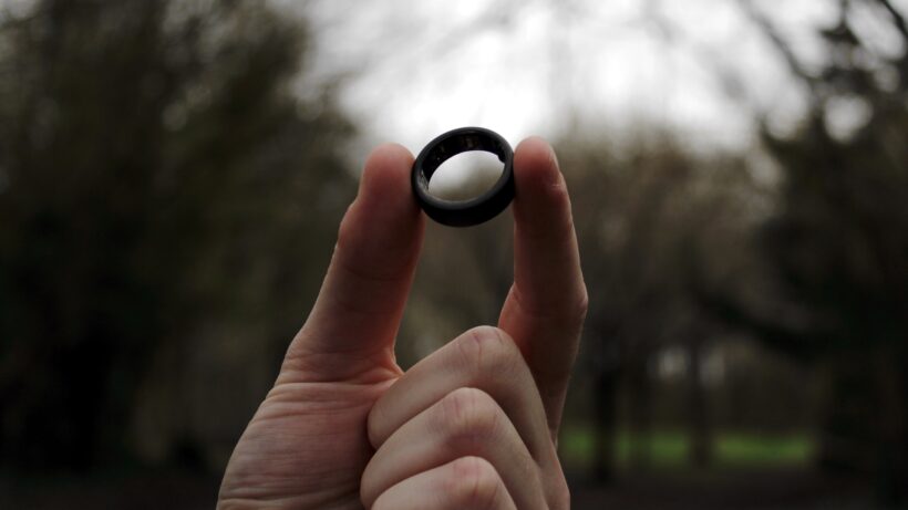 smart ring held up in forest